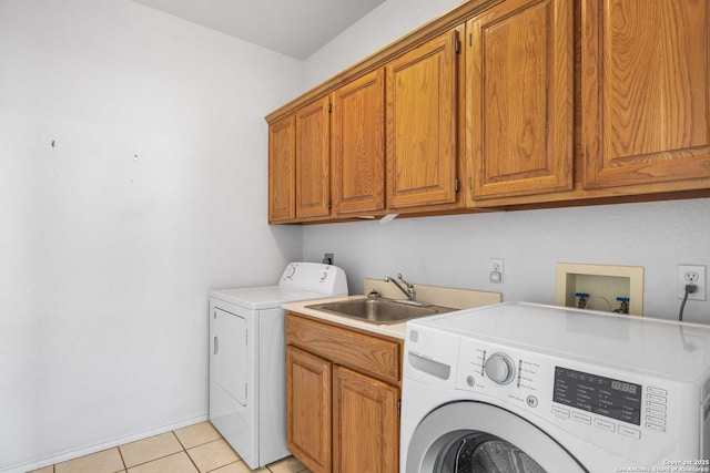 laundry room with cabinets, sink, light tile patterned floors, and washer and clothes dryer