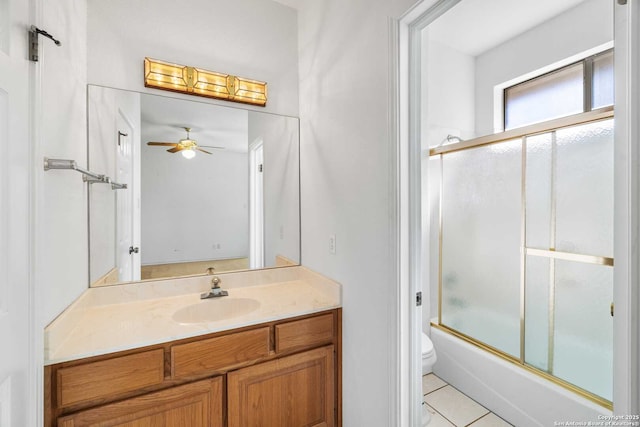 full bathroom featuring combined bath / shower with glass door, vanity, ceiling fan, toilet, and tile patterned floors