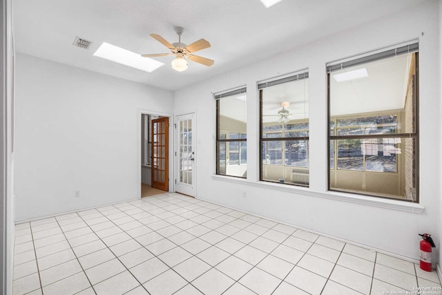 empty room featuring a skylight and ceiling fan