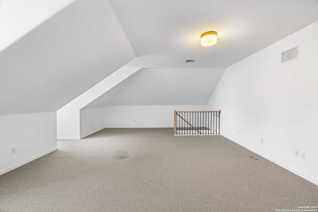 bonus room featuring vaulted ceiling and carpet flooring