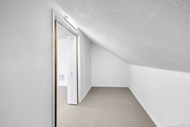 bonus room with lofted ceiling, a textured ceiling, and carpet flooring