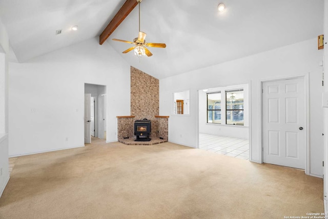 unfurnished living room featuring high vaulted ceiling, light carpet, a wood stove, ceiling fan, and beam ceiling