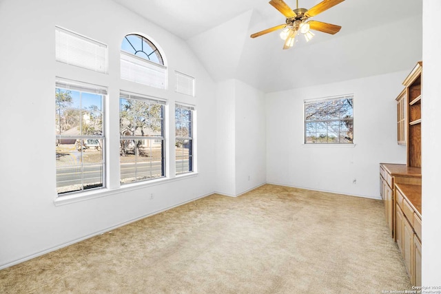 unfurnished living room with ceiling fan, vaulted ceiling, and light carpet