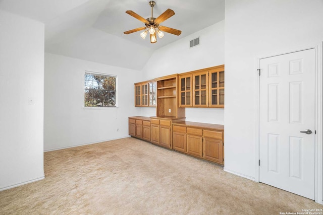 interior space featuring lofted ceiling, light colored carpet, and ceiling fan