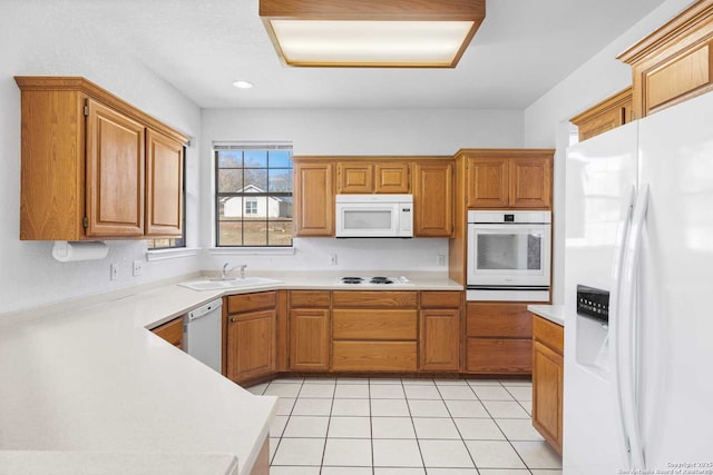 kitchen featuring sink, light tile patterned floors, and white appliances