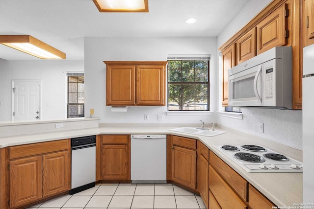 kitchen featuring white appliances, sink, and light tile patterned floors