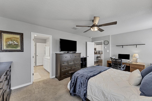 bedroom with ceiling fan, light colored carpet, a textured ceiling, and ensuite bath