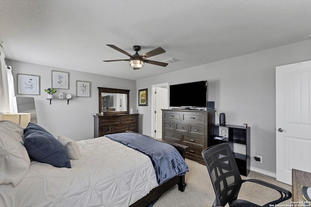 carpeted bedroom with ceiling fan and a textured ceiling