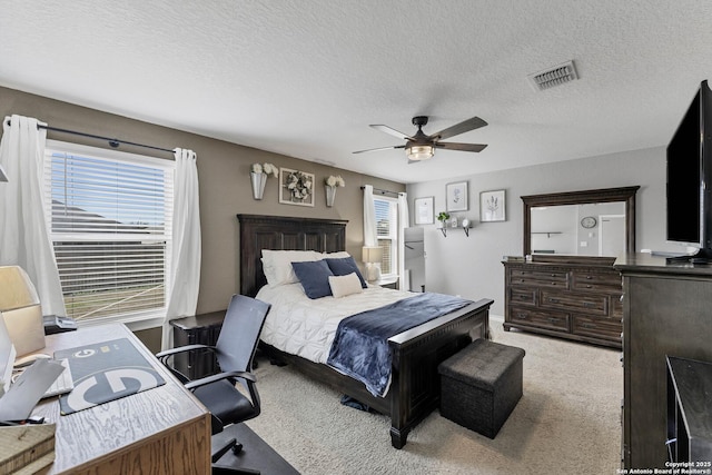 carpeted bedroom featuring a textured ceiling and ceiling fan