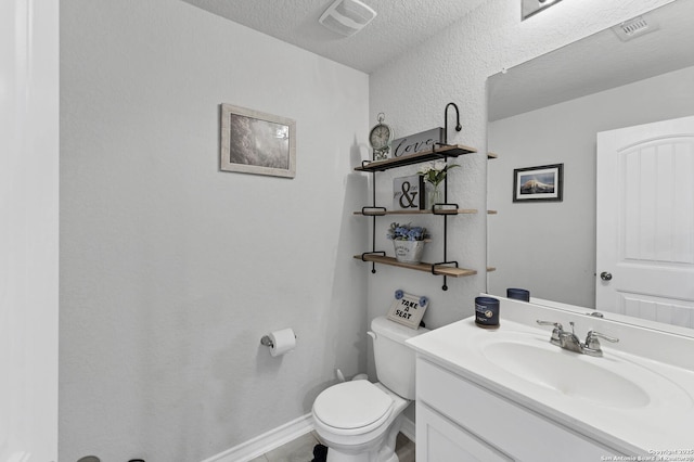 bathroom featuring vanity, a textured ceiling, and toilet