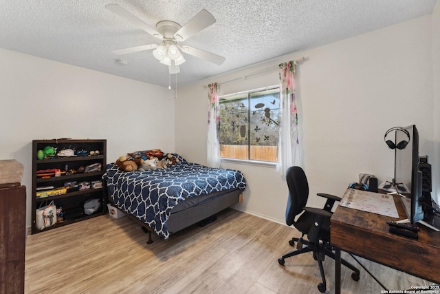 bedroom featuring ceiling fan, light hardwood / wood-style floors, and a textured ceiling