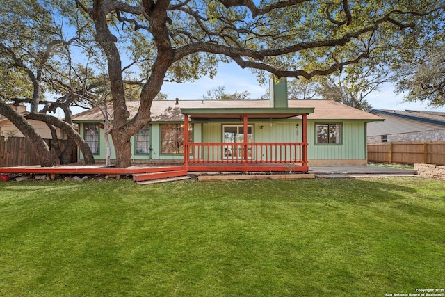 rear view of property featuring a deck and a lawn