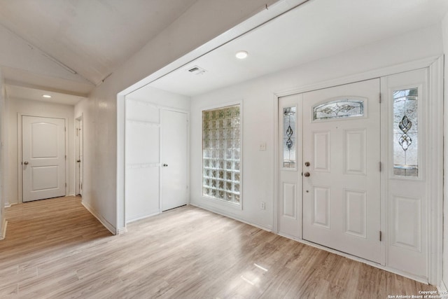 foyer entrance with vaulted ceiling and light hardwood / wood-style floors