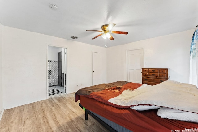 bedroom featuring hardwood / wood-style flooring, connected bathroom, and ceiling fan