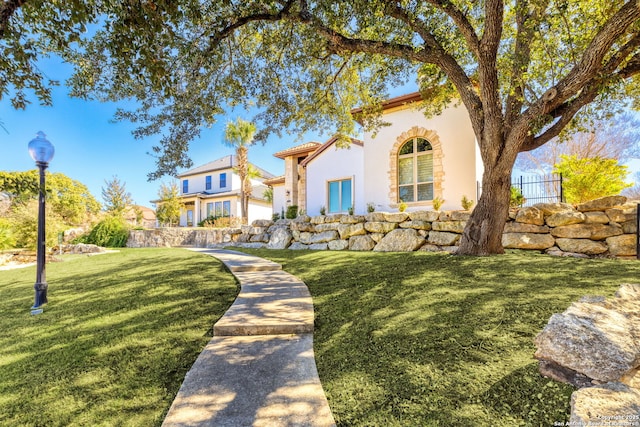 mediterranean / spanish-style home with a front lawn