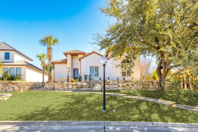 mediterranean / spanish-style house featuring a front lawn