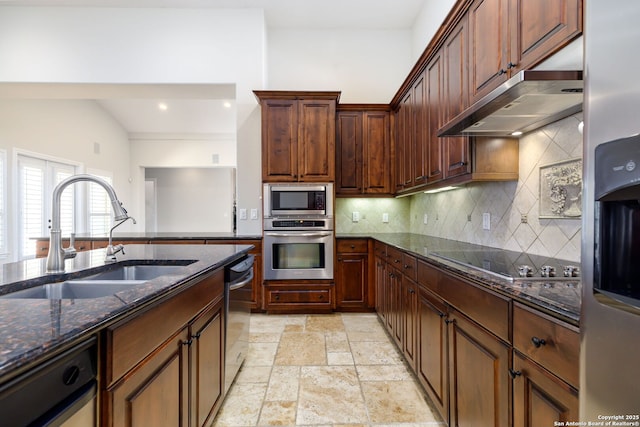 kitchen with appliances with stainless steel finishes, range hood, sink, dark stone countertops, and decorative backsplash