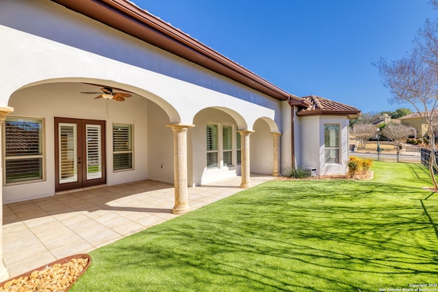 back of property with a yard, a patio, and ceiling fan