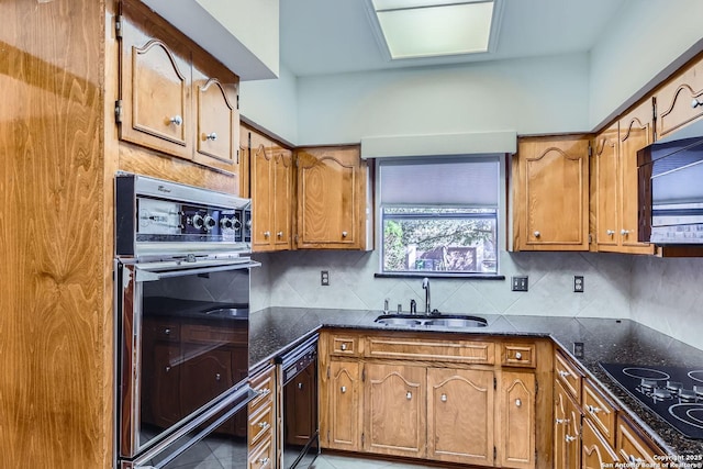 kitchen featuring light tile patterned flooring, sink, dark stone countertops, backsplash, and black appliances