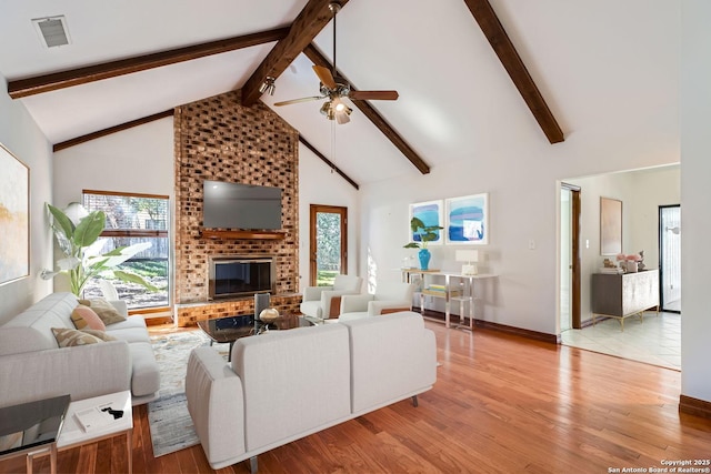 living room featuring a brick fireplace, high vaulted ceiling, and light hardwood / wood-style flooring