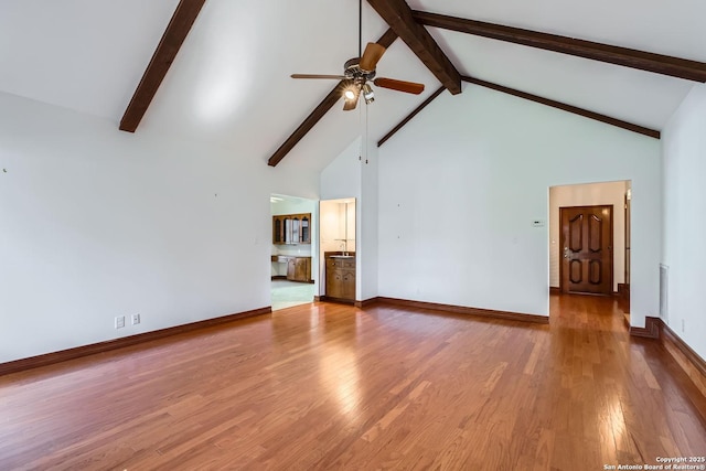 unfurnished living room with beamed ceiling, ceiling fan, high vaulted ceiling, and hardwood / wood-style floors