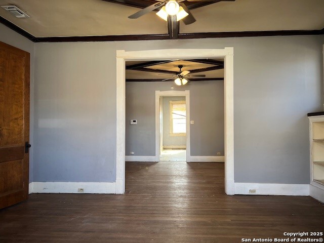 spare room featuring dark hardwood / wood-style flooring, ornamental molding, and ceiling fan