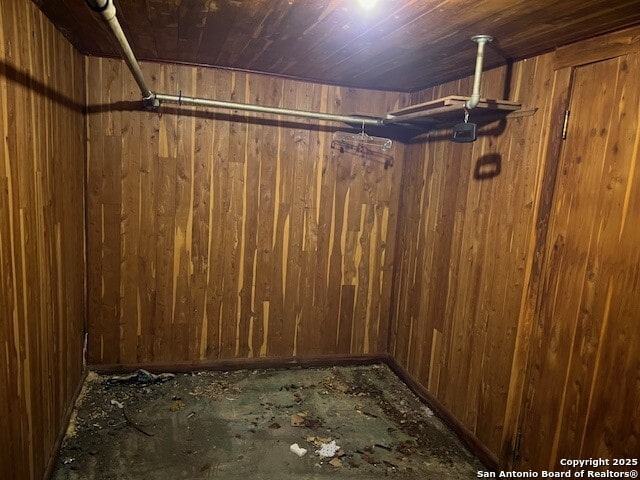 basement featuring wood ceiling and wood walls