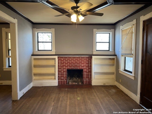 unfurnished living room featuring a fireplace, ornamental molding, and dark hardwood / wood-style flooring