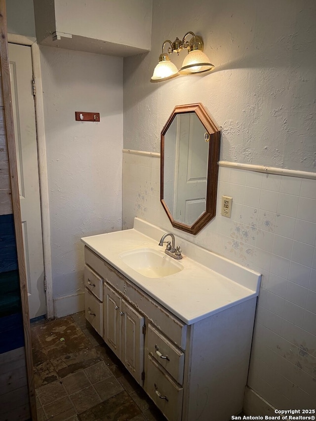 bathroom with vanity and tile walls