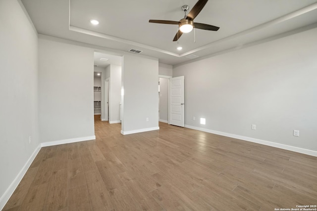 211 Ryan Xing, San Antonio, TX 78253 - unfurnished bedroom featuring a tray ceiling, baseboards, recessed lighting, and wood finished floors