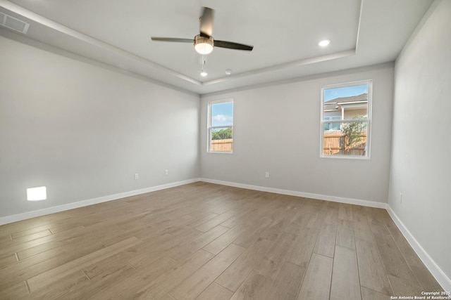 211 Ryan Xing, San Antonio, TX 78253 - empty room featuring a tray ceiling, healthy amount of natural light, ceiling fan, light wood-style floors, and recessed lighting