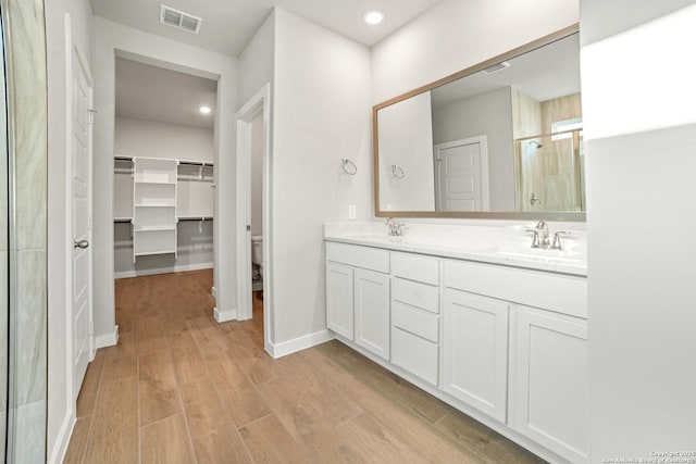 211 Ryan Xing, San Antonio, TX 78253 - full bath featuring a stall shower, double vanity, toilet, wood finished floors, and a walk in closet
