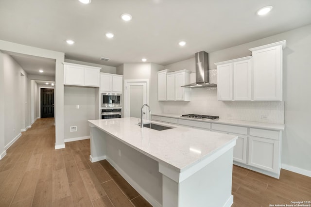 211 Ryan Xing, San Antonio, TX 78253 - kitchen featuring wall chimney exhaust hood, a sink, appliances with stainless steel finishes, light wood-style flooring, and decorative backsplash