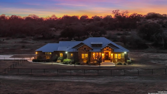 view of front facade featuring metal roof, a fenced front yard, and driveway