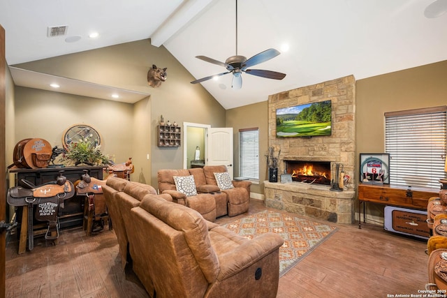 living area with beam ceiling, a fireplace, ceiling fan, wood finished floors, and high vaulted ceiling