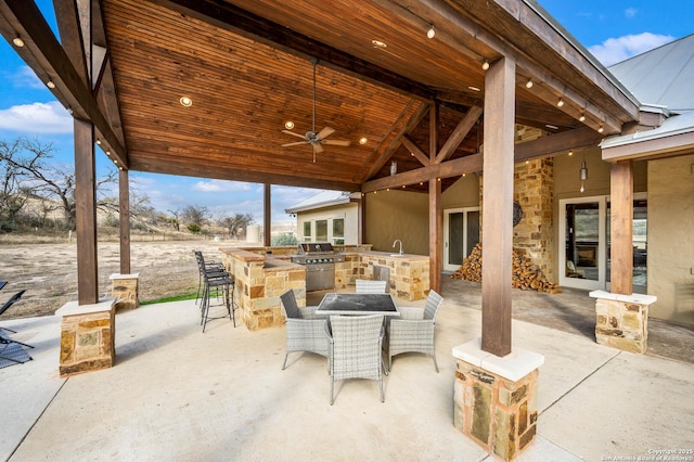 view of patio / terrace with an outdoor kitchen, a ceiling fan, a grill, outdoor wet bar, and a sink