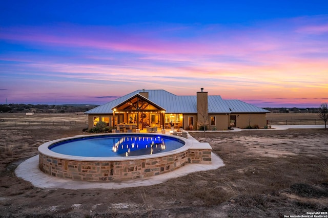 pool at dusk featuring an outdoor pool