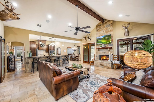 living area featuring arched walkways, high vaulted ceiling, visible vents, beam ceiling, and stone tile flooring