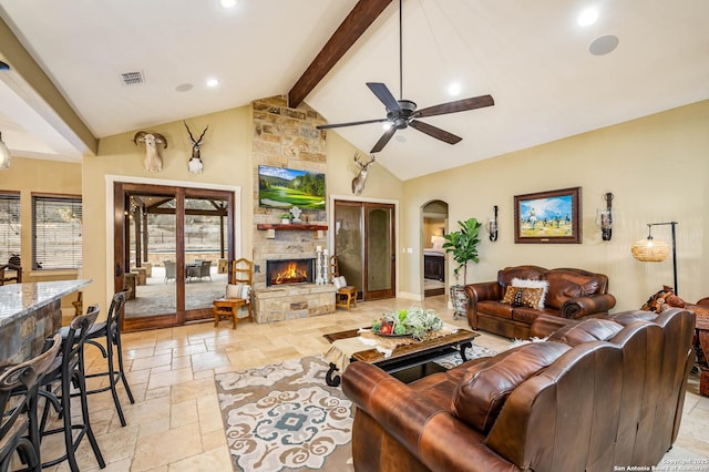 living room featuring arched walkways, stone tile flooring, a fireplace, high vaulted ceiling, and beam ceiling