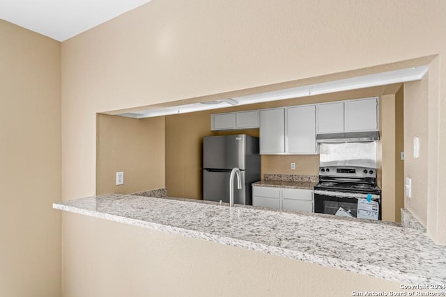 kitchen featuring stainless steel appliances, light stone countertops, white cabinets, and kitchen peninsula