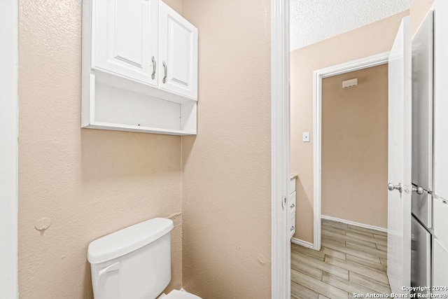 bathroom featuring toilet and a textured ceiling