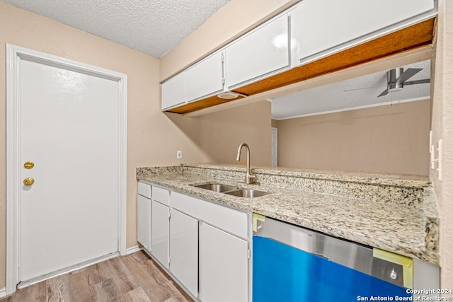 kitchen with sink, white cabinetry, light hardwood / wood-style floors, a textured ceiling, and stainless steel dishwasher