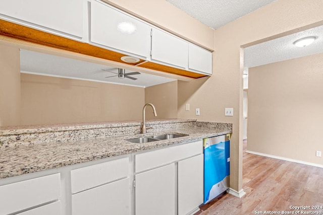 kitchen featuring sink, dishwasher, white cabinetry, a textured ceiling, and light wood-type flooring