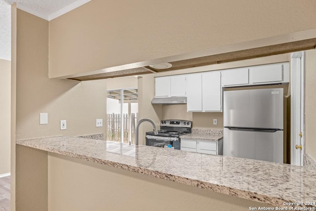 kitchen featuring light stone countertops, white cabinetry, appliances with stainless steel finishes, and kitchen peninsula