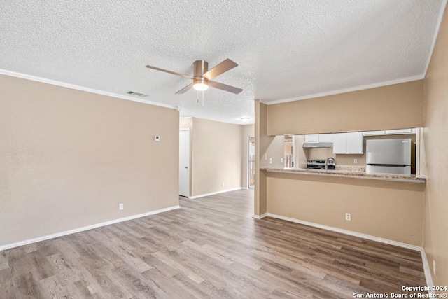 unfurnished living room with a textured ceiling, ornamental molding, ceiling fan, and light wood-type flooring