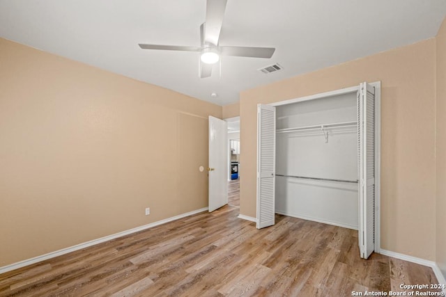 unfurnished bedroom featuring ceiling fan, light hardwood / wood-style floors, and a closet