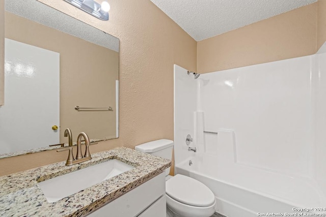 full bathroom with shower / bathing tub combination, vanity, toilet, and a textured ceiling