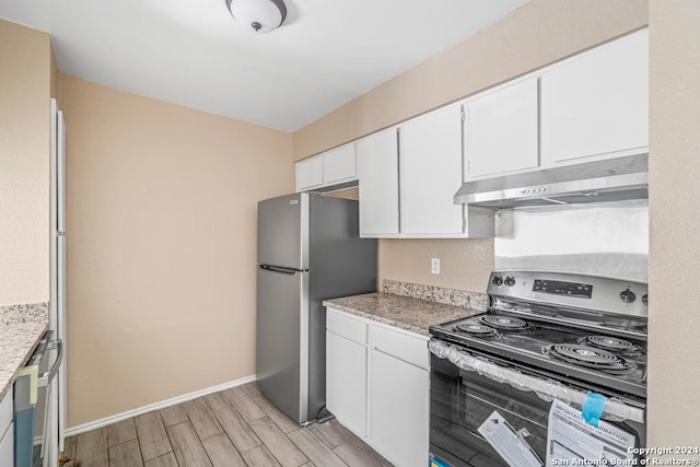 kitchen featuring electric stove, stainless steel refrigerator, and white cabinets