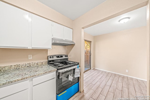 kitchen with white cabinets, light stone counters, and stainless steel electric range