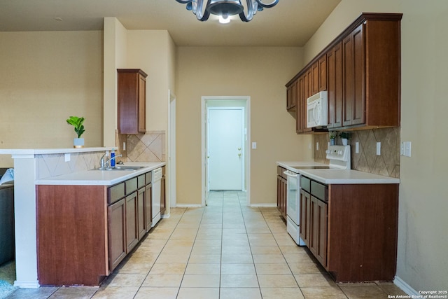 kitchen featuring sink, a chandelier, light tile patterned floors, white appliances, and decorative backsplash